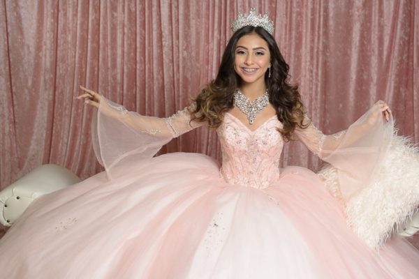 Quinceañera woman posing for a picture in a pink ball gown