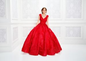 A woman in a red quinceanera gown posing for a picture