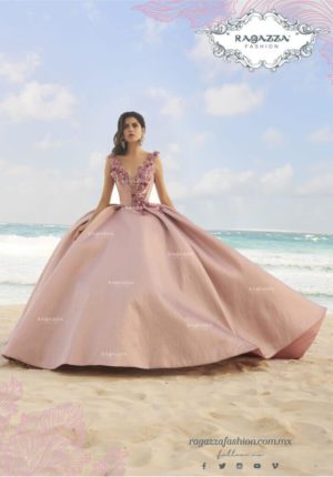 Quinceañera dresses - a woman in a pink dress sitting on the beach