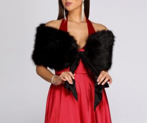 A woman wearing a red dress and black fur stole, with fur clothing