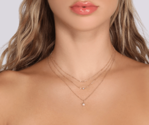 A close up of a woman wearing earrings and a necklace for a Quinceanera event