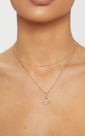 A woman wearing a gold necklace with a coin on it for a Quinceanera