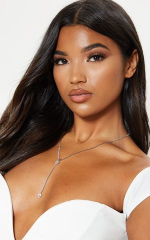 A fashion model wearing a white dress and a necklace at a Quinceanera