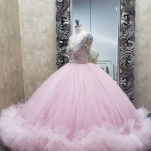 A pink Quinceanera gown sitting in front of a mirror