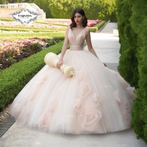 A woman in a Quinceanera gown walking down a path