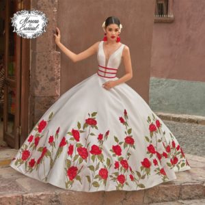 A woman in a white and red Quinceañera dress posing with gown Quinceañera dresses.