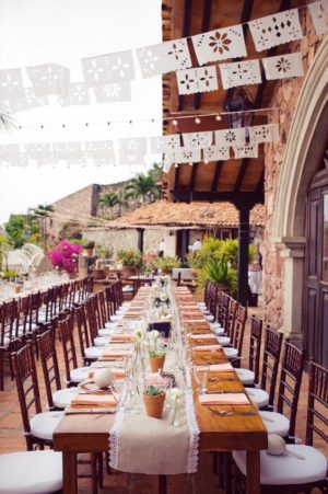 A Quinceanera function hall, with a long table set with place settings for a party