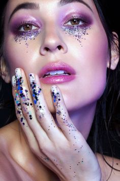 A woman with glitter on her face and nails, ready for her Quinceanera celebration