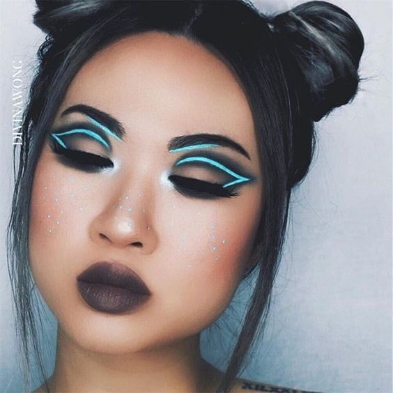 A woman with black hair and futuristic makeup, with blue accents