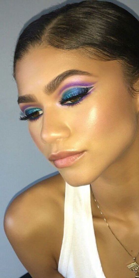 A Quinceanera woman with a white top and purple eyeshadow, creating a captivating Euphoria makeup look