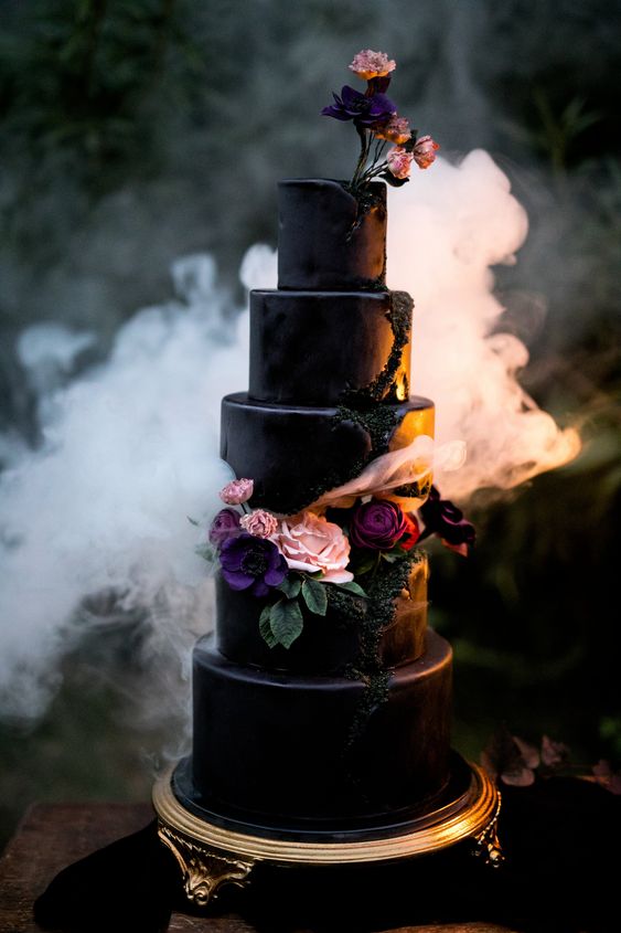 A winter-themed Quinceanera cake with three tiers. The cake is black and decorated with flowers on top.