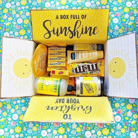 A Quinceanera-themed image showing a box full of sunshine gifts and products sitting on a table.